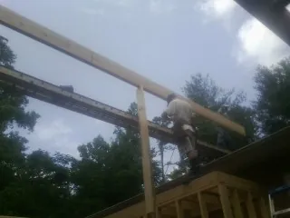 Carpenter setting a ridge beam over a new addition frame — Ice Dam Removal by Roofing Brothers in Eyota