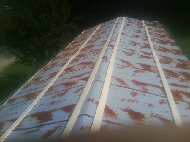 Rusted metal roof panels with new wood purlins before replacement — Storm Damage Roof Repair in Eyota by Roofing Brothers