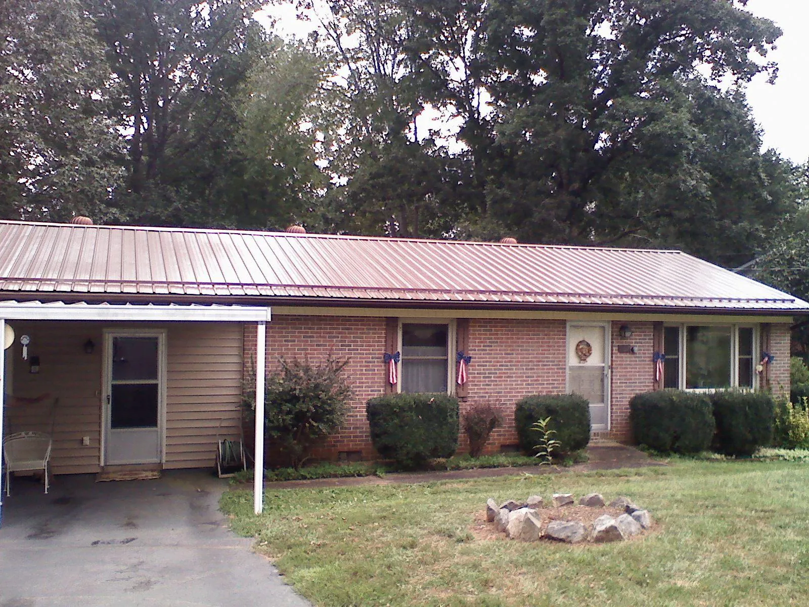Bronze metal roof and carport on a brick ranch home — Roof Repair work by our crew in Eyota